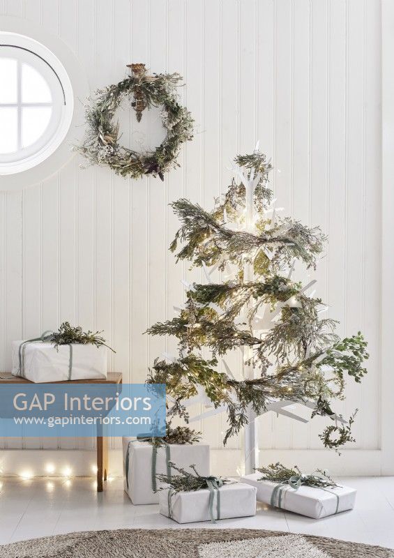 Sapin de Noël en bois blanc décoré de guirlandes naturelles