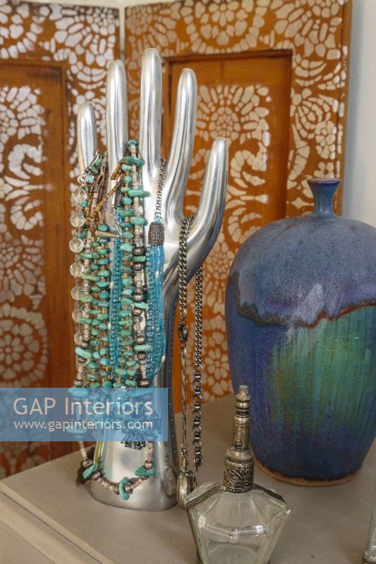 Des colliers, de la poterie et une bouteille de Marrakech résument le style local et mondial de Debbie.