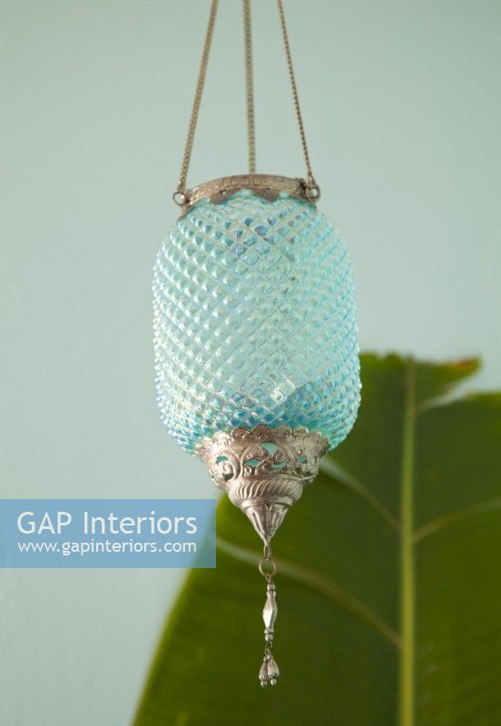 Une lanterne aqua en verre taillé ajoute une touche d'intrigue et complète la palette de couleurs.