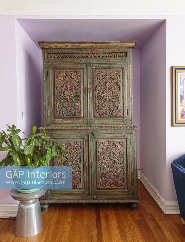 Une armoire sculptée et peinte en Inde offre un placard indispensable dans la maison de 800 pieds carrés de Bridget.
