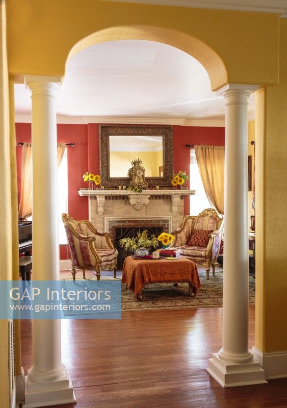 Des murs dorés et une ouverture cintrée encadrent élégamment l'entrée du salon.