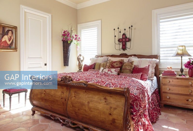 La couleur du linge de lit se reflète dans la pièce dans les carreaux de sol Saltillo hexagonaux cuivrés, les peintures et autres accents décoratifs.
