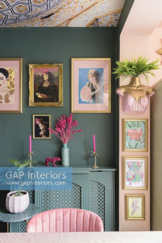Détail du mur de galerie d'images de style salon et du cache-radiateur dans une pièce verte et rose pâle