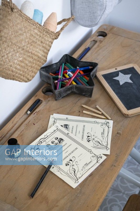 Detail of writing accessories on childrens wooden school desk 