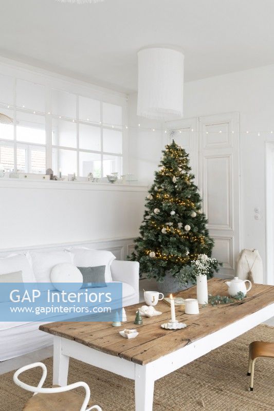 Arbre de Noël décoré dans un salon peint en blanc