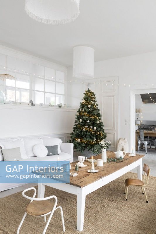 Arbre de Noël décoré dans un salon peint en blanc