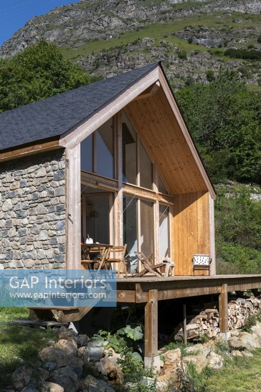 Petite cabane en pierre et bois à côté de la montagne