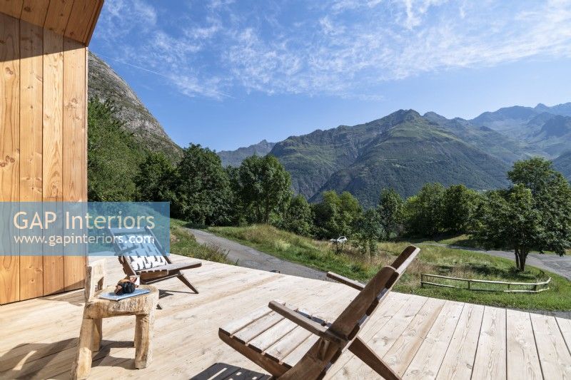 Chaises en bois sur la terrasse avec vue panoramique sur les montagnes