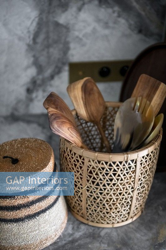 Panier de cuillères en bois sur plan de travail de cuisine en marbre - détail