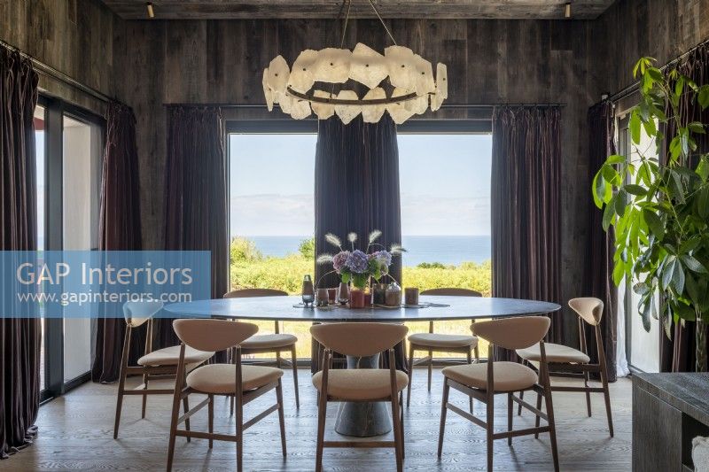 Salle à manger élégante avec vue sur la côte à travers de grandes fenêtres