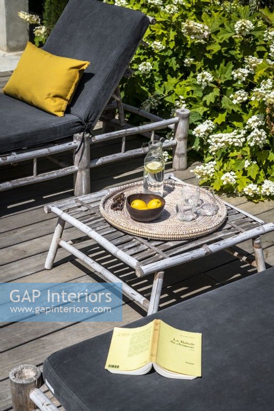 Fauteuils inclinables et petite table en osier sur la terrasse en été