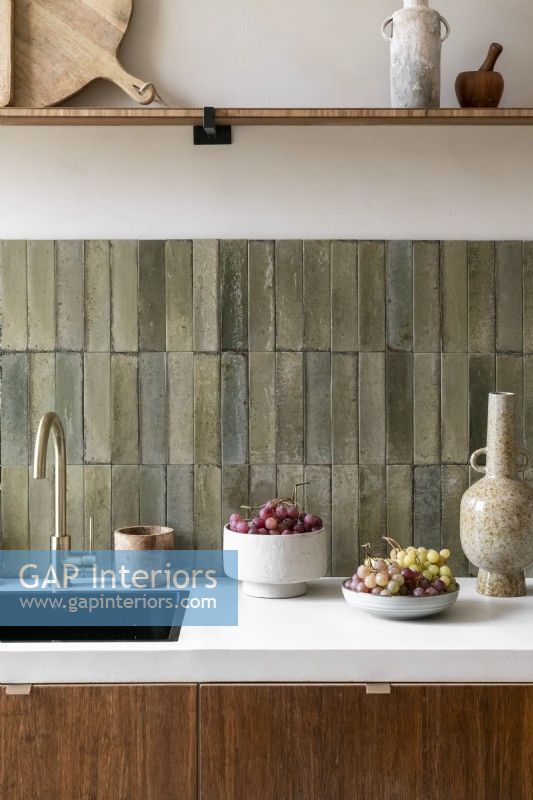 Stone tiled splashbacks and sink in contemporary kitchen