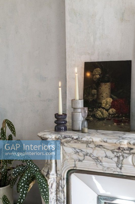 Détail de la peinture et des bougies sur une cheminée en marbre