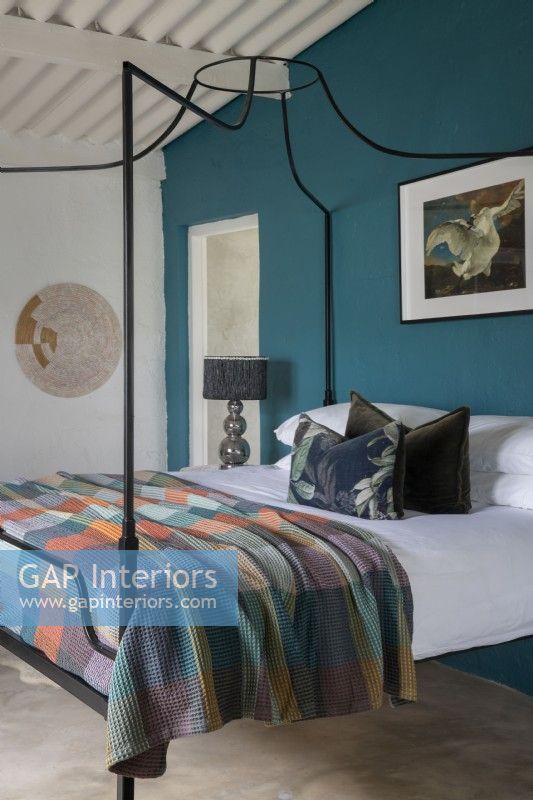 Chambre avec lit à baldaquin et mur décoratif bleu sarcelle