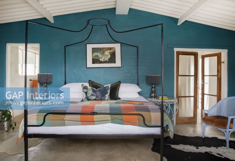 Chambre avec lit à baldaquin et mur d'accent bleu sarcelle