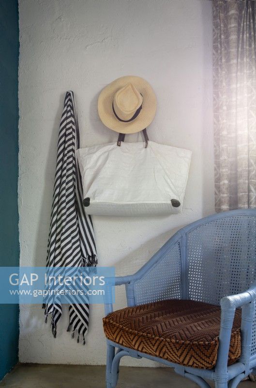 Sarong, sac et chapeau de soleil suspendus au-dessus d'une chaise en rotin