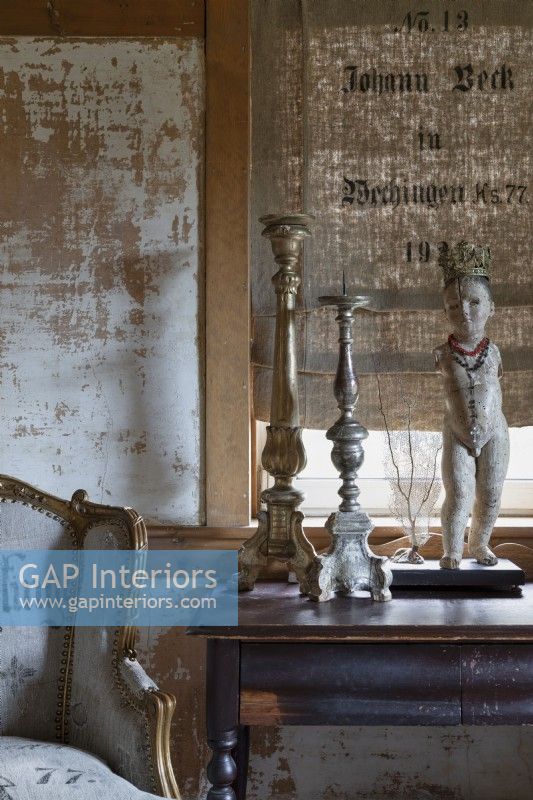 Détail de sculpture et grands chandeliers sur table en bois