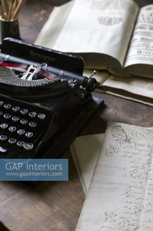 Détail de vieux livres et une machine à écrire vintage sur un bureau en bois