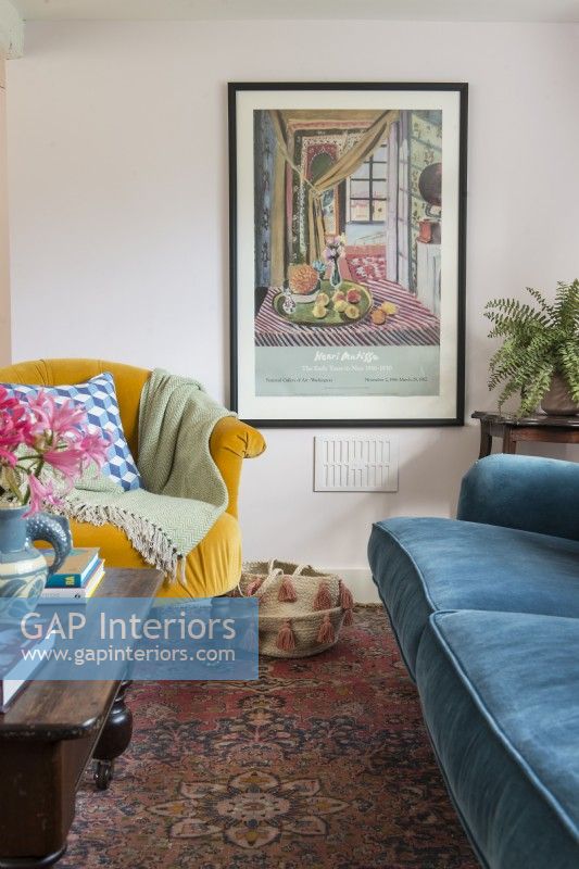 Affiche encadrée sur le mur du salon avec des meubles colorés