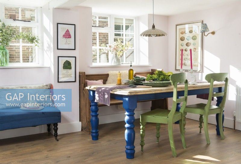 Table et chaises peintes en vert et bleu dans la salle à manger de campagne