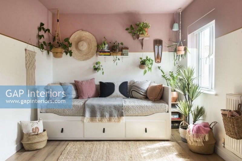 Canapé-lit de repos entouré de plantes d'intérieur
