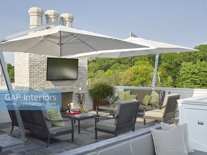 Un toit-terrasse au design moderne avec cheminée, télévision et parasols 