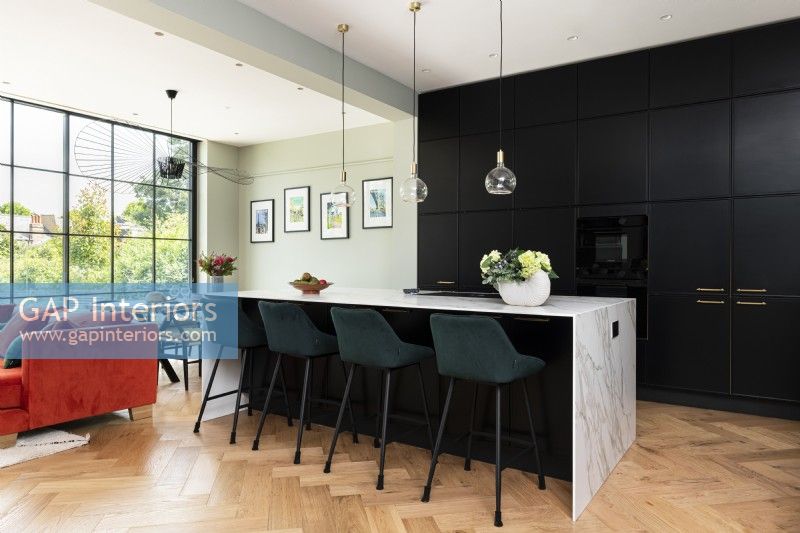 Large modern kitchen with tall black wall units and island.