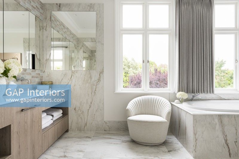 Grande salle de bain classique contemporaine avec double vasque, baignoire et carrelage en marbre. 