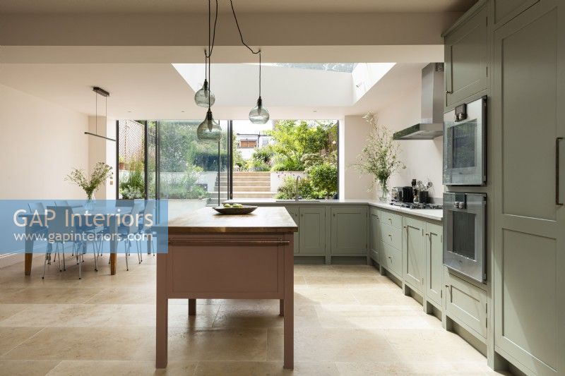 Classic contemporary large kitchen with free standing pink island and views into the garden.