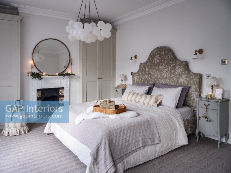 Chambre neutre avec tête de lit décorative et éclairage fonctionnel 