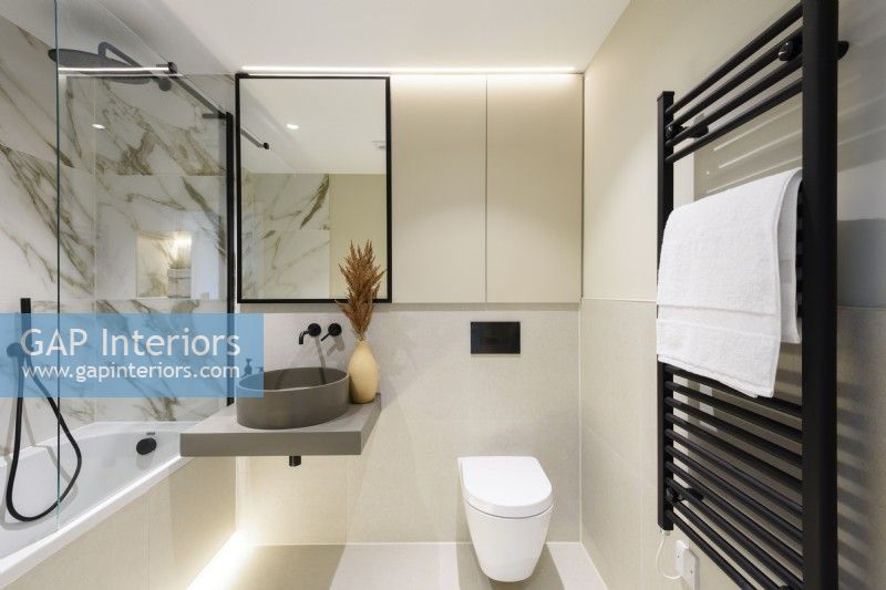 Salle de bains moderne avec murs en marbre et accessoires noirs 