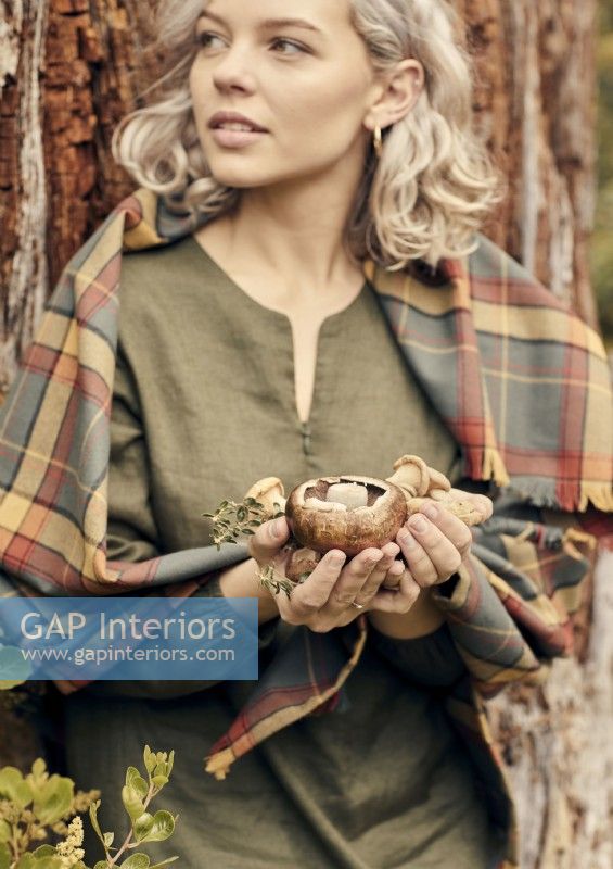 Portrait de jeune femme tenant des champignons fourragers 
