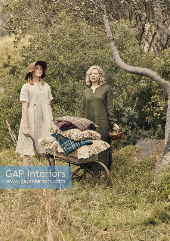 Deux femmes avec une brouette antique dans les bois 