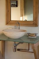 Ferme Boonshill, East Sussex. Intérieur de la salle de bain avec vasque en pierre sur plateau en verre.