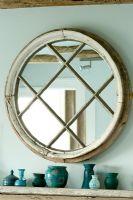ferme Boonshill, East Sussex. Intérieur de la chambre à coucher avec miroir fabriqué à partir de l'ancienne fenêtre et de la poterie par Lisette Pleasance