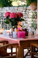 Villa Christina, Kaminaki, Corfou, Grèce. Terrasse couverte avec coin repas et table en bois et chaises pour dîner en plein air