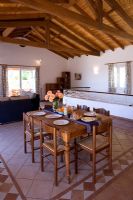 Villa Christina, Kaminaki, Corfou, Grèce. Salon et salle à manger à aire ouverte avec table et sol carrelé en pierre