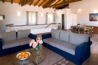 Villa Christina, Kaminaki, Corfou, Grèce. Salon et salle à manger décloisonnés avec canapés et table à manger