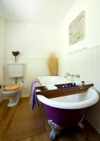 Salle de bain rustique avec baignoire surélevée violette