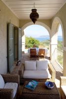 Corfou, Grèce. Yialiskari House Villa près de Kalami. Terrasse avec chaises longues en osier, table et vue sur les montagnes albanaises