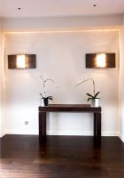Couloir moderne avec table et orchidées avec éclairage contemporain