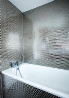 Salle de bain contemporaine moderne avec baignoire blanche et carreaux de mosaïque effet nid d'abeille argent