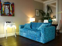 Salon moderne avec canapé en tissu à motif bleu et éclairage ambiant