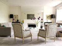 Salon classique avec fauteuils à motifs et canapés gris