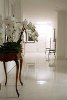 Couloir blanc classique avec table console et sol en marbre