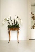 Table console avec affichage d'orchidées dans le couloir