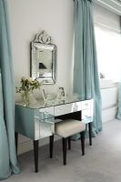 Chambre classique avec coiffeuse miroir et miroir orné et rideaux bleu canard