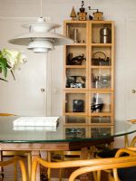 Salle à manger de style scandinave avec table et chaises, Louis Poulsen lumière au-dessus de la table et meuble de rangement en arrière-plan