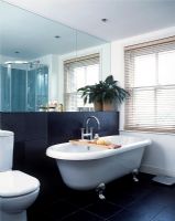 Salle de bain classique avec baignoire sur pieds, grand miroir et carrelage mural et sol en ardoise noire