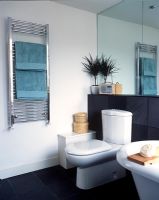 Salle de bain moderne avec WC, radiateur sèche-serviettes et carrelage mural et sol en ardoise noire